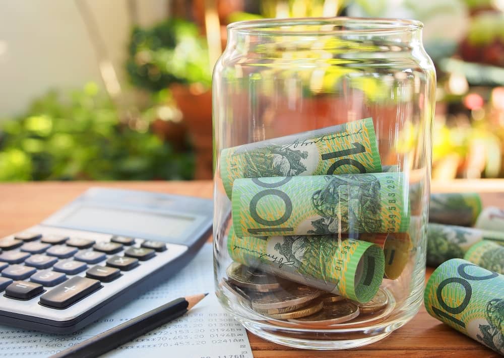 Australian bank notes inside glass jar.